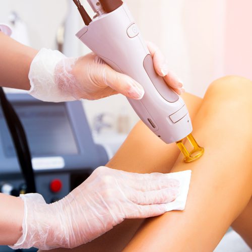 close-up-female-cosmetologist-medical-coat-making-young-woman-procedure-laser-hair-removal-leg-cosmetology-ionization-diamond-procedures