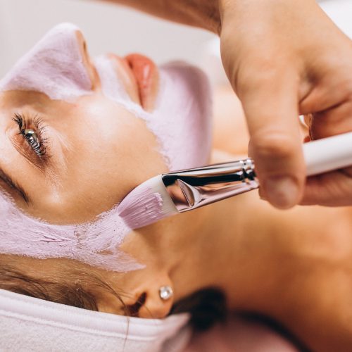 cosmetologist-applying-mask-face-client-beauty-salon-2
