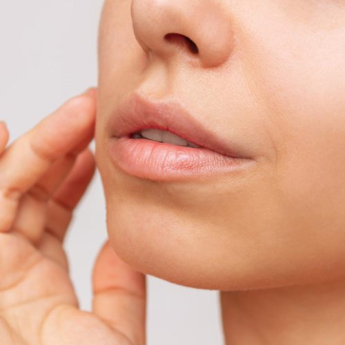 young-caucasian-woman-touching-cheek-applying-cream-face-with-her-hand